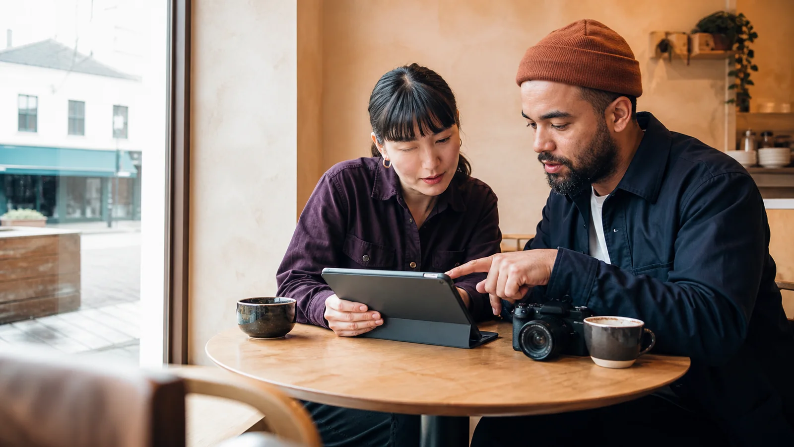 Local business owner and creator planning a neighborhood campaign together in a cafe