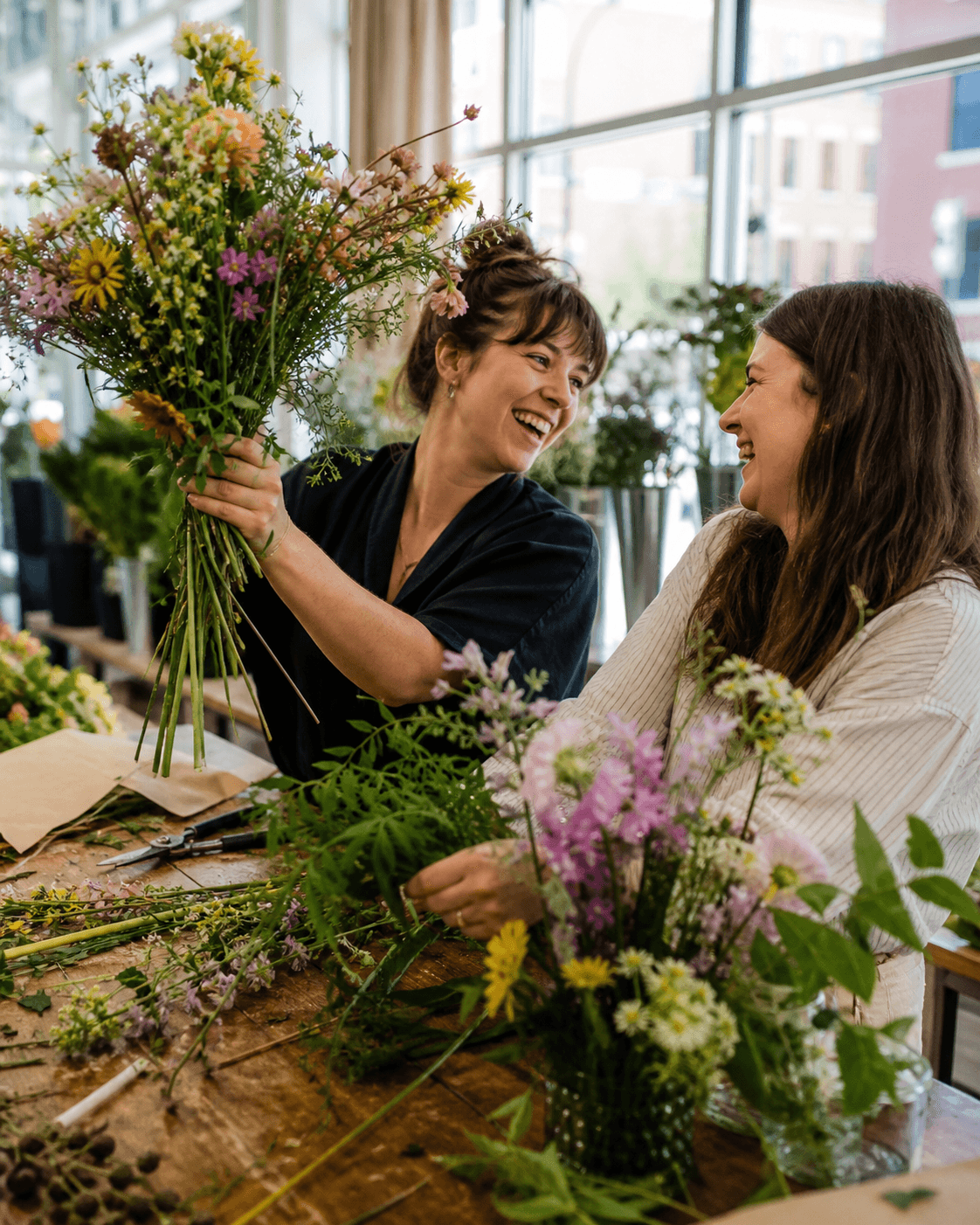 A floral business owner welcoming a guest to a hands-on experience