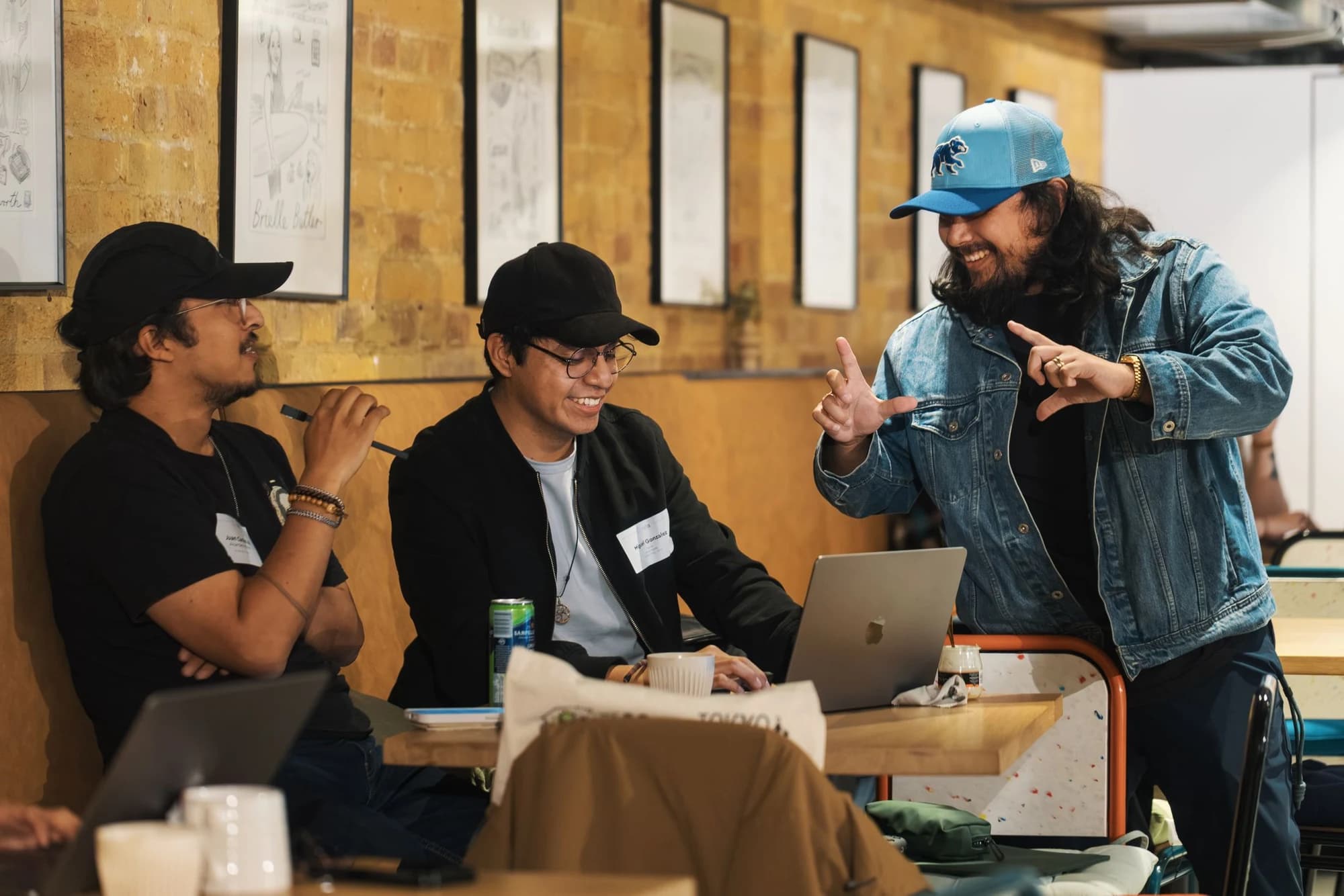 Three people reviewing a laptop together in a cafe